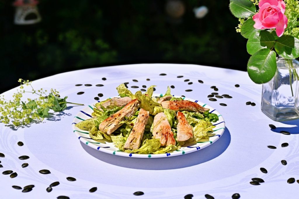 Putenstreifen auf Blattsalat, dekorativ angerichtet auf einem Teller.